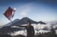 Top 50 Indonesian Phrases to Learn Before Your Trip 1 man wearing black crew neck sweater holding white and red flag standing near mountain under blue and white sky
